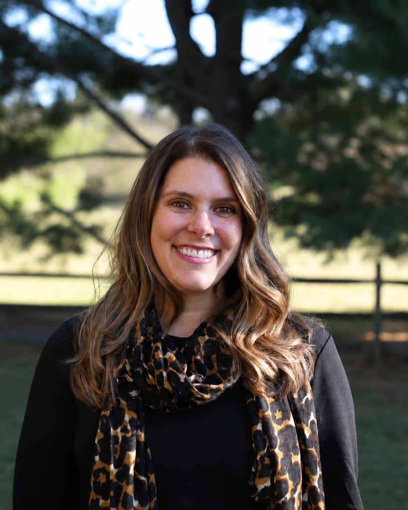 Mara Berger, founder of RootED Path Consulting, smiling outdoors